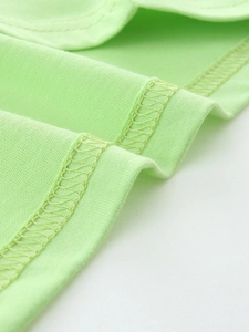 Détail du t-shirt en coton vert clair pour garçon montrant la couture de finition surfilée
