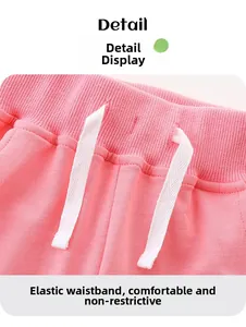 Close-up of pink knit shorts showing elastic waistband and white round drawstring