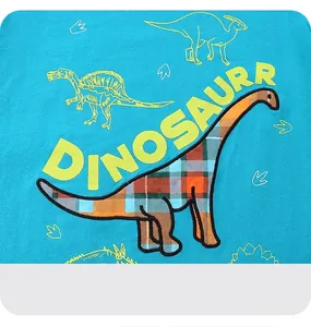 Close-up of blue kids t-shirt with embroidered dinosaur patch and printed dinosaur motif