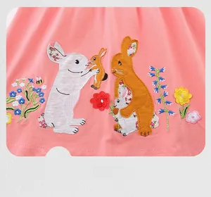 Close-up of cute rabbit embroidery with flowers on pink cotton girl's summer dress