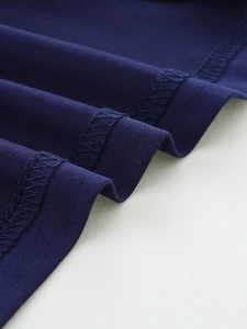 Dettaglio della cucitura piatta sull'orlo e trama in cotone blu navy della t-shirt bimbo