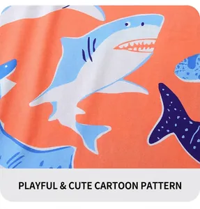 Gros plan détaillé d'un tricot doux avec motif requin bleu sur fond orange pour enfants