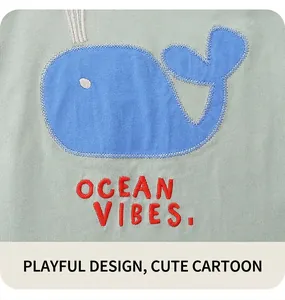 Detail of cute blue whale applique and Ocean Vibes embroidery on a green kids' cotton top