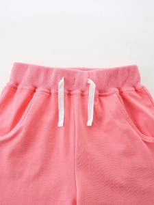 Pink girls' knitted shorts with elastic waistband and drawstring detail, flat lay view