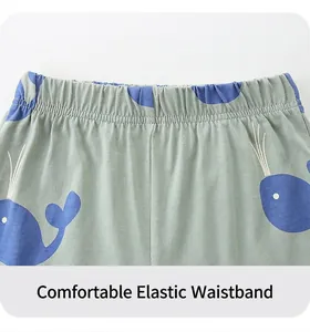 Detail of elastic waistband on boys' green knit shorts with blue whale print