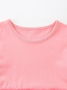 Robe d'été rose pour fille montrant les détails du col rond et la texture du tricot
