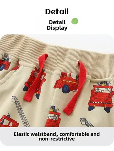 Detail of khaki cotton boys' shorts with red drawstring and cartoon fire truck print