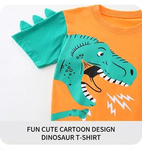 Detail eines Jungen-T-Shirts mit orangefarbenem Dino-Print und grünen 3D-Rückenflossen