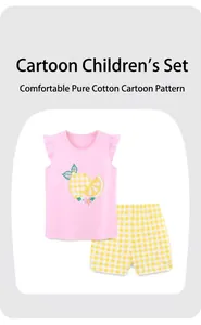 Detail of pink cotton girl's top with lemon print and yellow checkered shorts