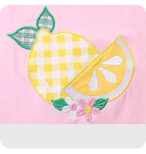 Detailed view of lemon applique and fine embroidery on pink cotton girl's t-shirt