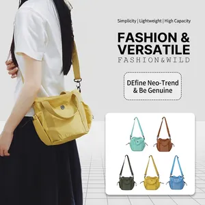 Detail of minimalist nylon crossbody bag showing dual handles and adjustable strap options