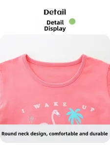 Detail eines rosa Baumwoll-T-Shirts mit Flamingo- und Palmen-Sommerprint am Ausschnitt