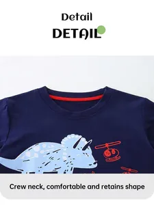Dettaglio della maglietta in cotone blu navy con stampe di dinosauri e elicotteri