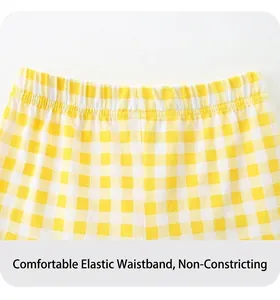 Close-up of girls' yellow gingham cotton pants featuring a comfortable elastic waistband