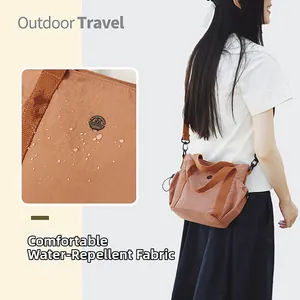 Water-repellent fabric detail on a caramel-colored crossbody bag for outdoor travel