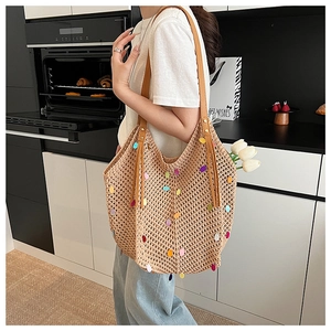 Detail of hollow knit tote bag with colorful sequins and brown leather straps