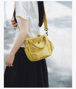 Side view of woman carrying a vibrant yellow crossbody bag with adjustable drawstring