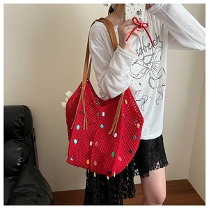 Detail of red crochet tote bag with colorful sequins and brown leather strap handles