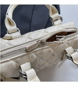 Dettaglio della cerniera argentata scorrevole su borsa trapuntata beige con strass