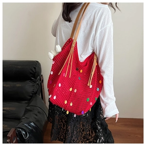 Detail of red crochet tote bag with colorful sequins and brown leather shoulder strap
