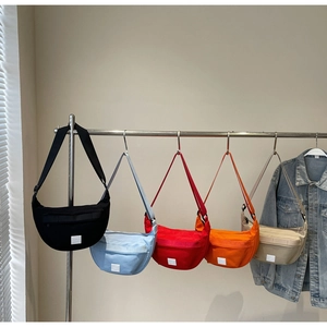 Détail de sacs bandoulière demi-lune en toile en cinq couleurs avec sangle réglable