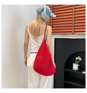 Detailed back view of a red crochet tote bag with brown leather straps for summer beach