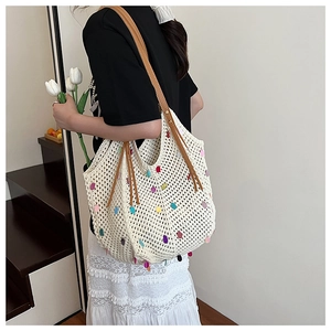 Detail of knit shoulder bag with colorful sequins and brown leather strap on model