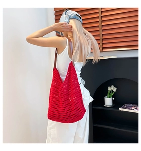 Detail of red hand-woven crochet tote bag with mesh hollow texture and leather straps