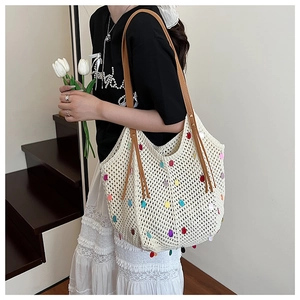 Detailed close-up of a crochet tote bag featuring multi-colored sequins and leather straps