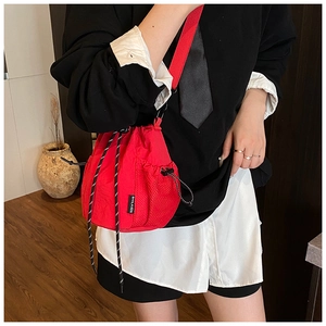 Detail of red drawstring nylon bucket bag with mesh side pocket and logo tag