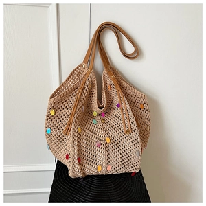 Detailed close-up of bohemian knit tote bag with colorful sequins and leather straps