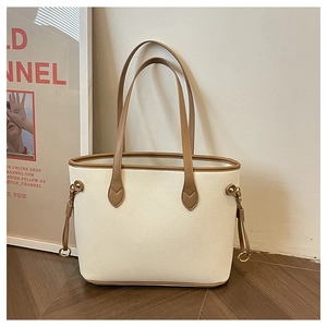 Detail of lychee pattern tote bag with cream body, brown trim and metal ring hardware