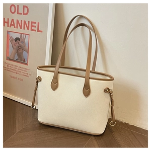 Detailed view of cream pebble leather tote with brown straps and side tassel detail