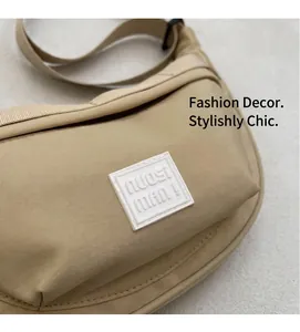 Détail du sac à bandoulière demi-lune beige avec logo et sangle tissée durable