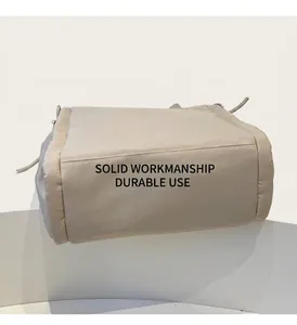 Dettaglio delle cuciture resistenti e della base ampia rinforzata della borsa beige