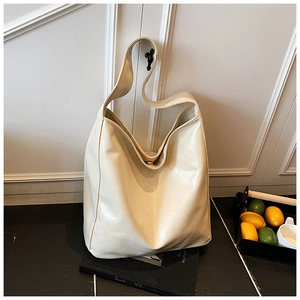 Detail of minimalist cream faux leather tote bag with wide strap for daily commute
