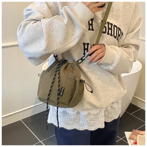 Detailansicht der armeegrünen Nylon-Beuteltasche mit seitlicher Netztasche und Gurt