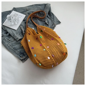 Close-up of knit tote bag with colorful sequins and brown leather shoulder strap