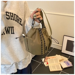 Detail of olive green canvas bucket bag with drawstring closure and side mesh pocket