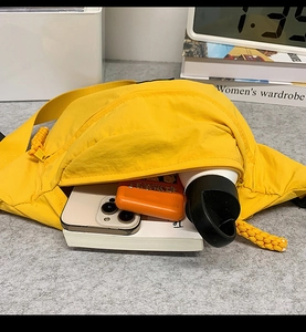 Interior view showing the large capacity of a bright yellow nylon crossbody bag
