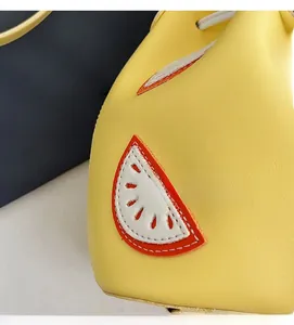 Close-up of yellow PU leather bag featuring a stitched watermelon pattern and fine texture