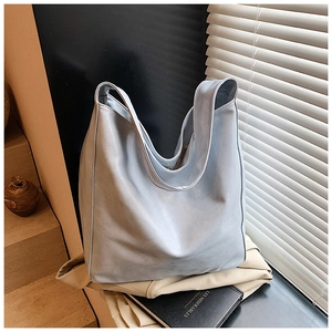 Macro shot of hazy blue leather texture and soft structure of a large hobo bag