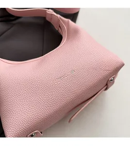 Detailed macro view of pink lychee grain leather texture and metallic rivet accents