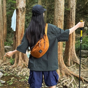 Outdoor crossbody bag in vibrant orange featuring durable nylon and wide shoulder straps