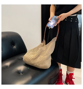 Detail of hollow woven tote bag with brown leather straps for summer beach vacations