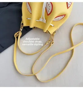 Detail view of yellow PU leather bucket bag with drawstring and adjustable shoulder strap