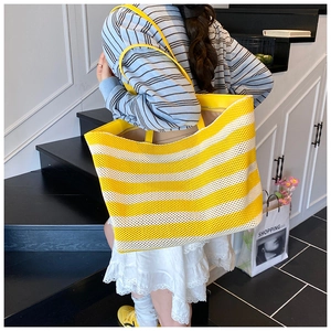 Détail du sac fourre-tout tricoté à rayures jaunes sur mannequin pour usage quotidien