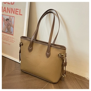 Detailed view of the brown leather tote bag with lychee texture and metallic ring detail