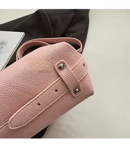 Detailed close-up of pink pebbled leather handbag with silver metallic rivet accents