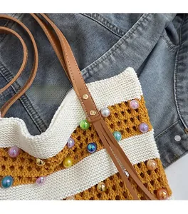 Détail d'un sac cabas en tricot rayé avec perles colorées et garnitures dorées